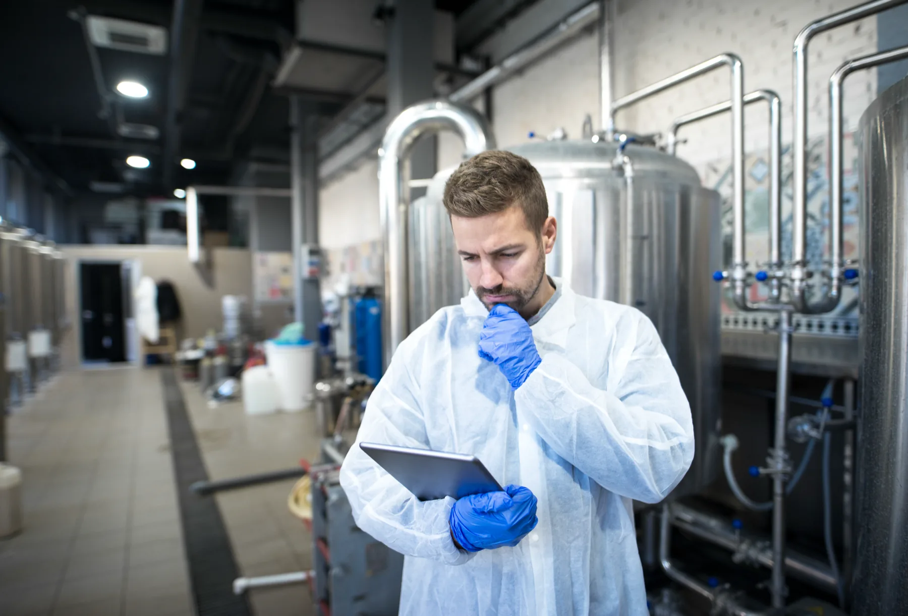 Profissional analisa informações operacionais em uma fábrica de alimentos